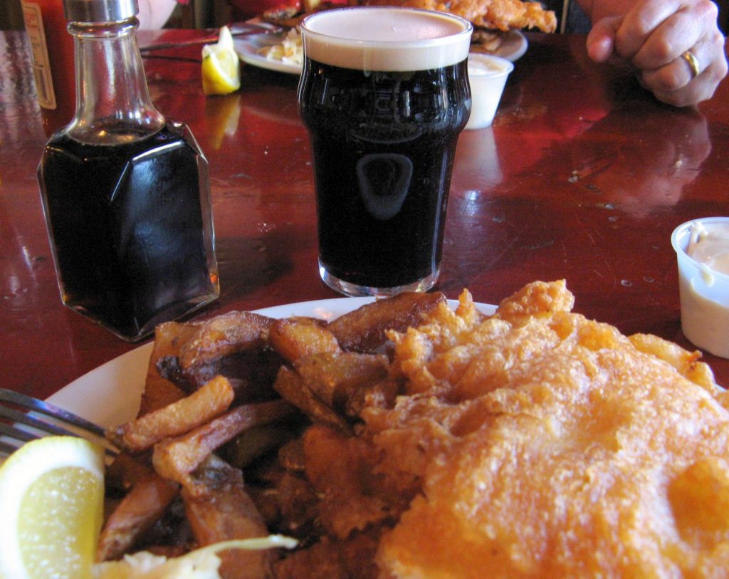 A pint of Guinness with fish and chips