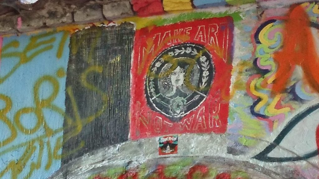 Peace sign and Make Art Not War painted on the Lennon Wall