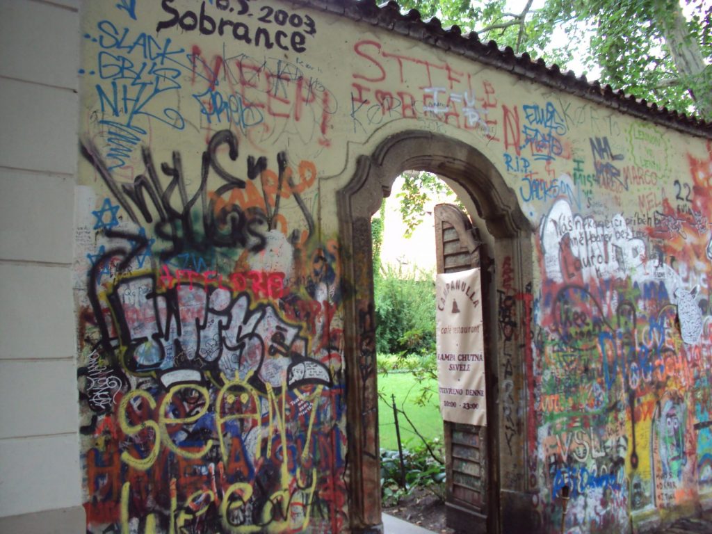 The Lennon Wall in Malá Strana covered in graffiti, with the garden gate