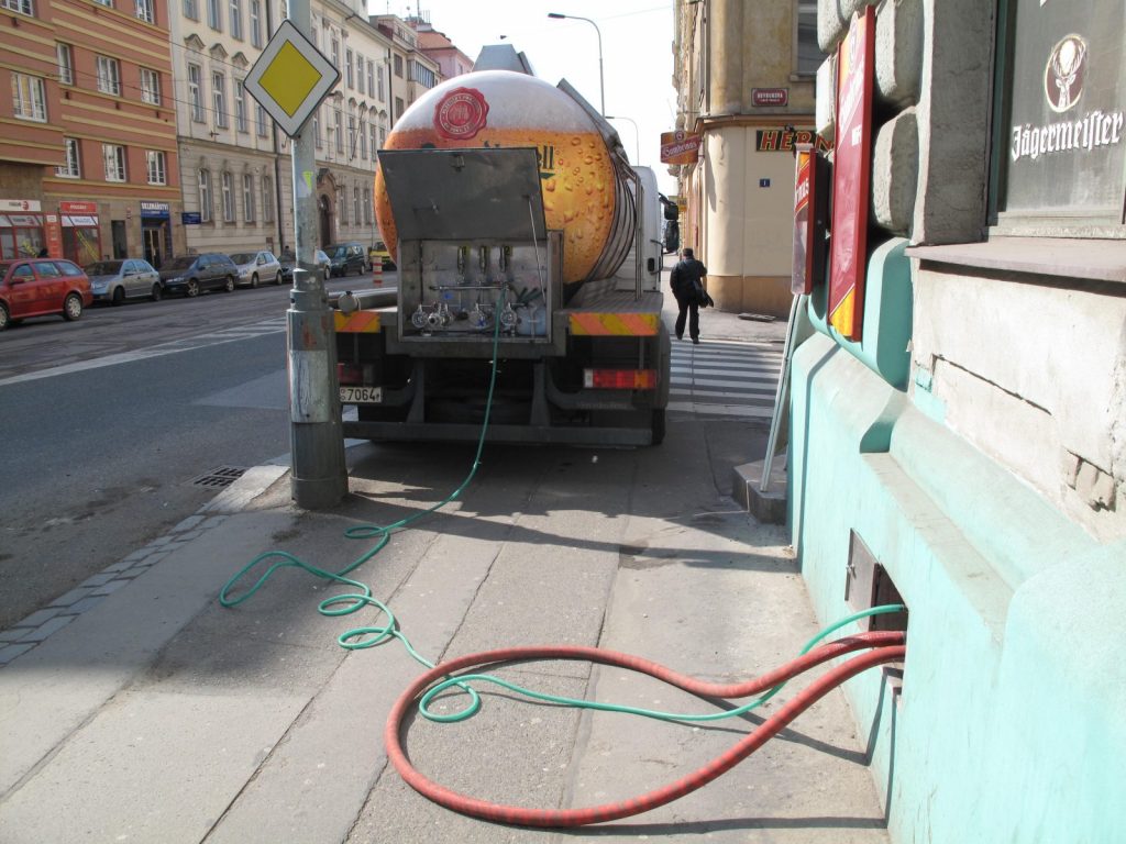 A tanker pumping Pilsner tank beer through a hose into a pub cellar